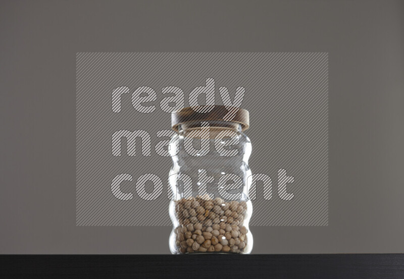 Chickpeas in a glass jar on black background