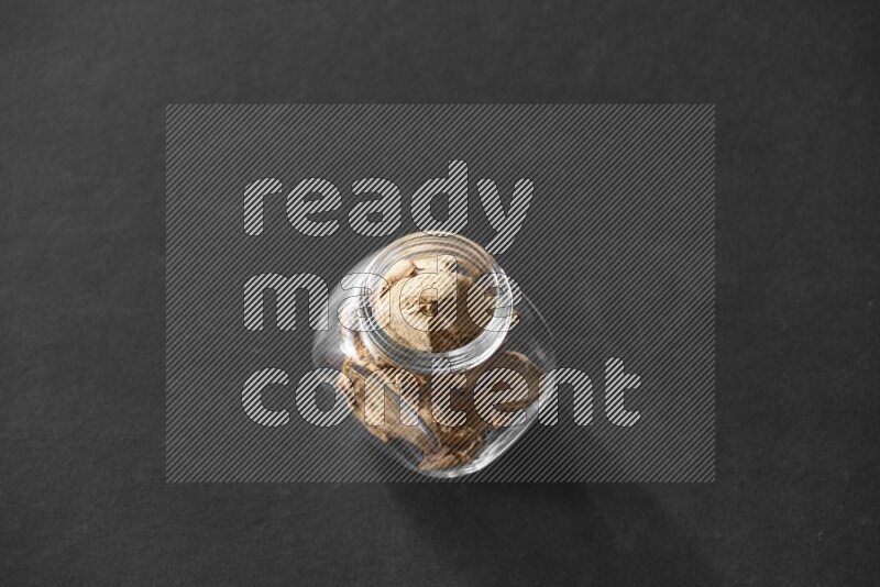 زنجبيل مجفف في وعاء زجاجي علي خلفية سوداء