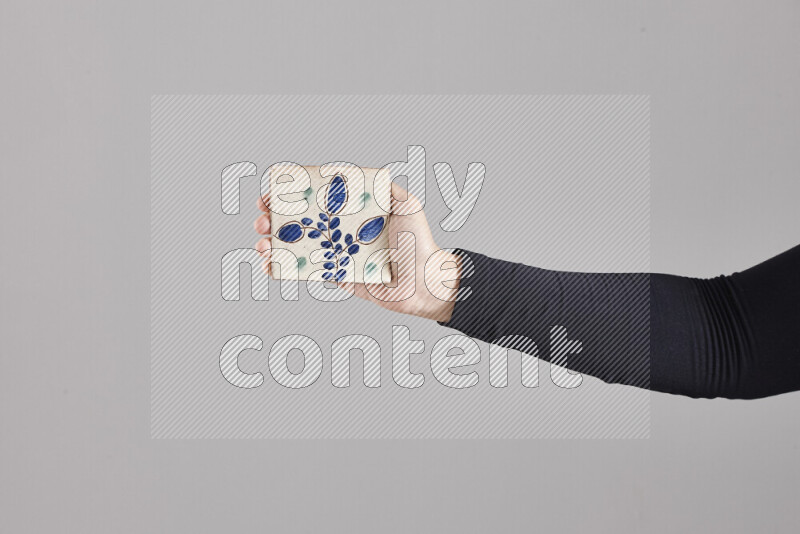 امرأة ترتدي عباءة سوداء تحمل أدوات فخارية مختلفة في أوضاع متعددة