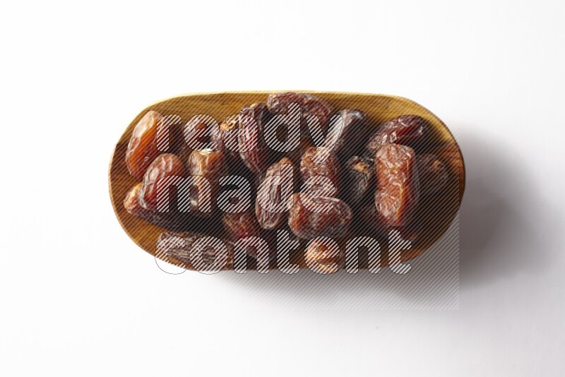 Dates in a wooden plate on white background
