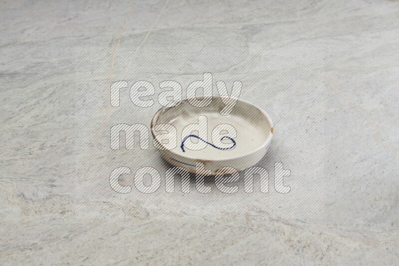A multicolored pottery bowl on grey marble background