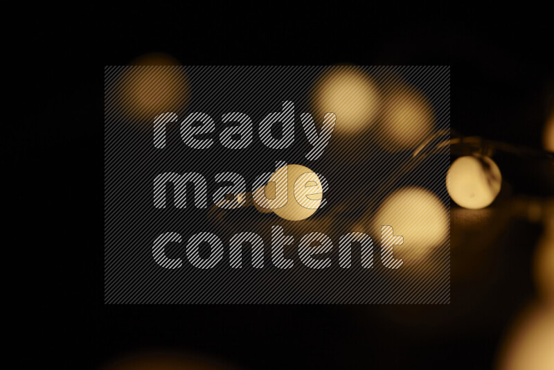 Light bulbs glowing against backdrop of golden bokeh