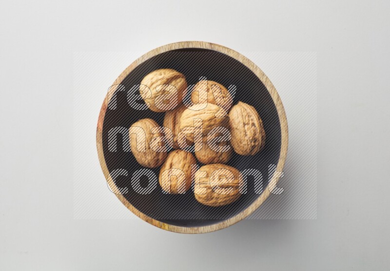 Top-view shot of walnut in a container on white background