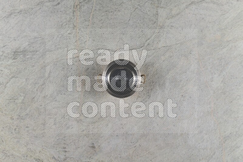 A small copper pot on grey marble background