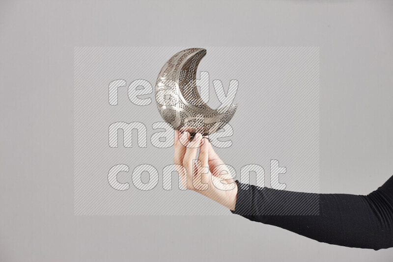 A woman in black abaya holding different ramadan lanterns in different positions