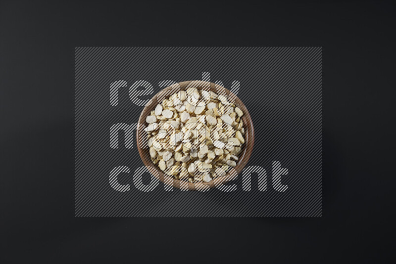 Crushed beans in a wooden bowl on grey background