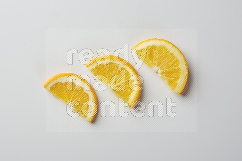 Three halves of an orange slices on white background