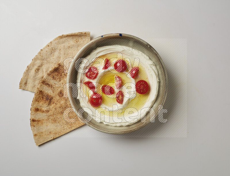 Lebnah garnished with cherry tomato in a grey pottery plate on a white background