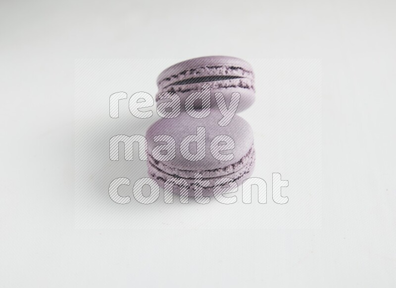 45º Shot of two Purple Blueberry macarons on white background