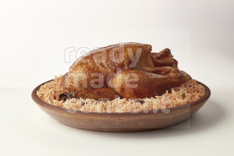 red basmati Rice with whole roasted chicken on a pottery plate direct on white background
