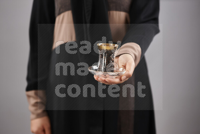 Woman in abaya holding different kinds of coffee beans in different positions