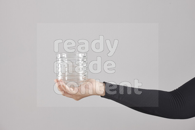 A woman in black abaya holding different glassware in different positions