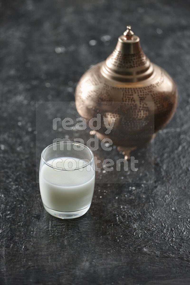 فانوس ذهبي مع مشروبات مختلفة وتمر ومكسرات وسبحة صلاة وقرآن على خلفية سوداء