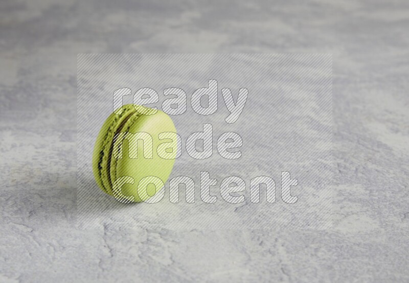 45º Shot of Yellow Lime macaron on white  marble background