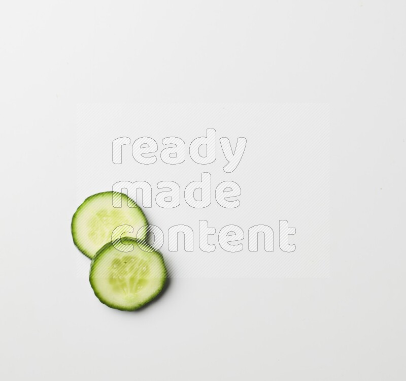 two cucumber slices on white background