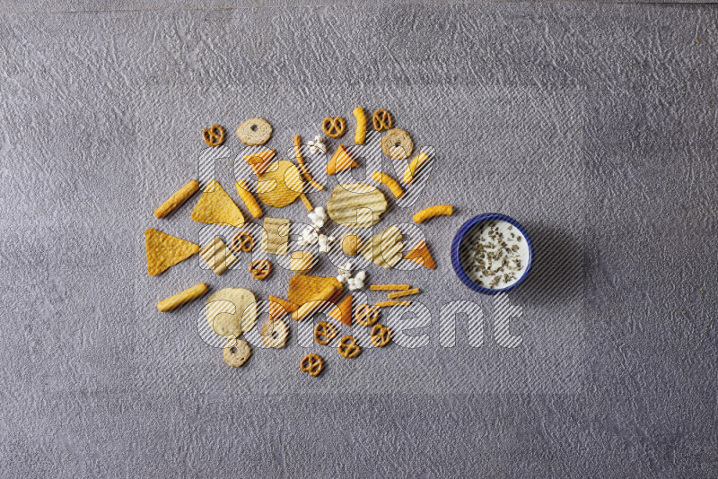 Assorted snacks in pottery bowls on grey background