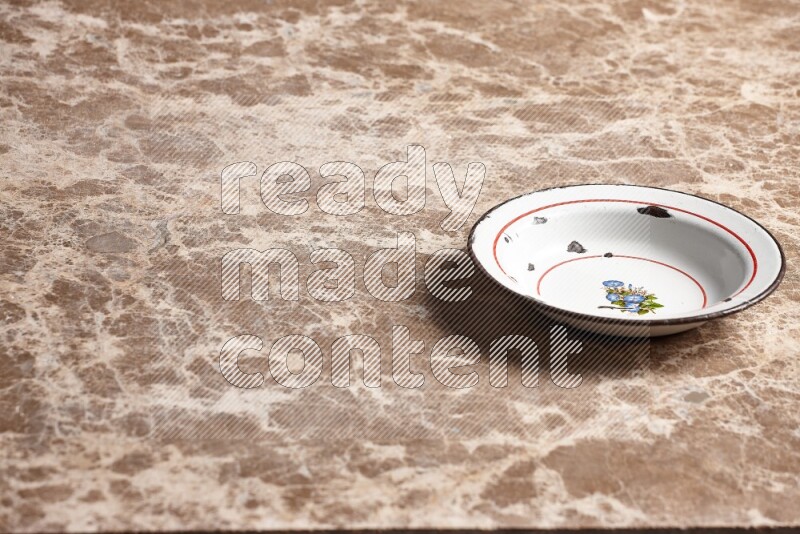 صحن معدني عتيق على خلفية رخام بيج