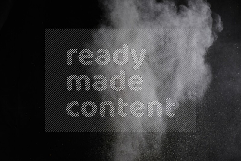 A side view of brown powder explosion on black background