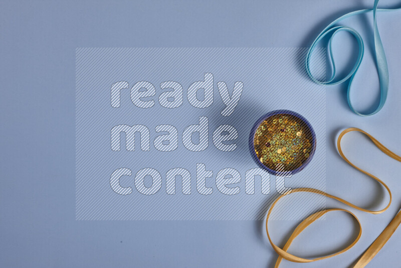 مجموعة من أدوات الخياطة والتفصيل صفراء وزرقاء اللون على خلفية زرقاء