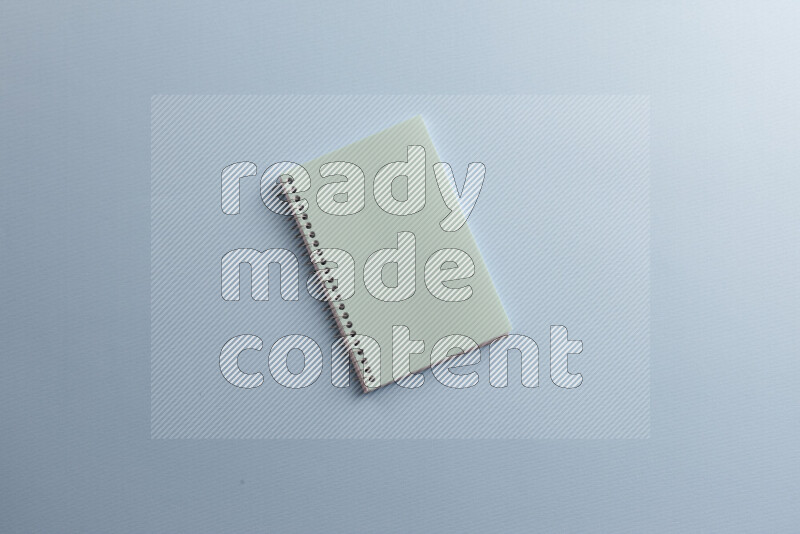A blue notebook with different school supplies on blue background