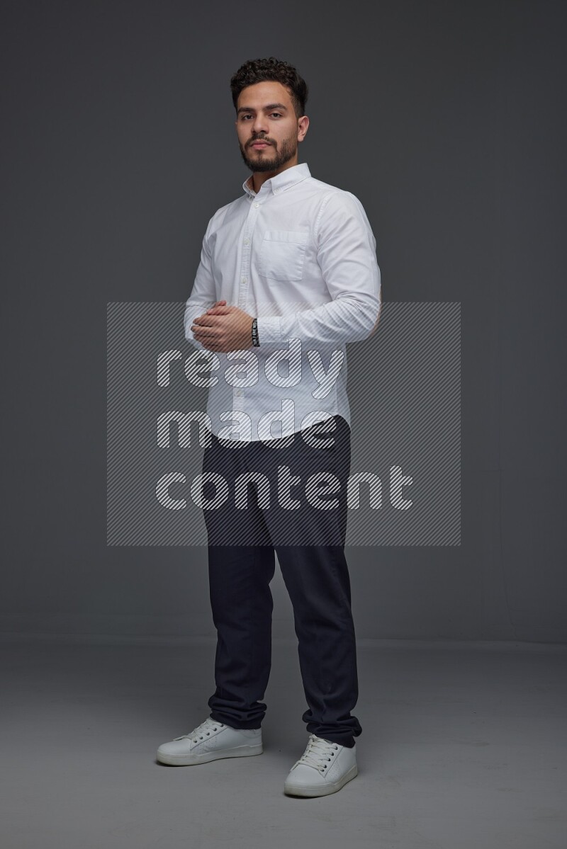 A man wearing smart casual making multi stand poses  eye level on a gray background