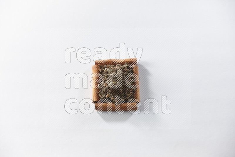A single square of cinnamon sticks full of dried basil on white flooring