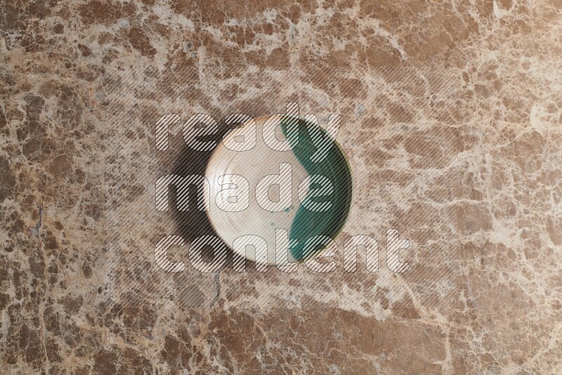 A decorative pottery plate on beige marble background