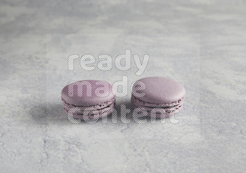 45º Shot of two Purple Blueberry macarons  on white  marble background