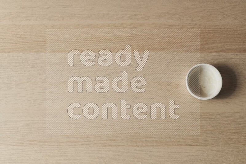 A white pottery bowl on light wooden background