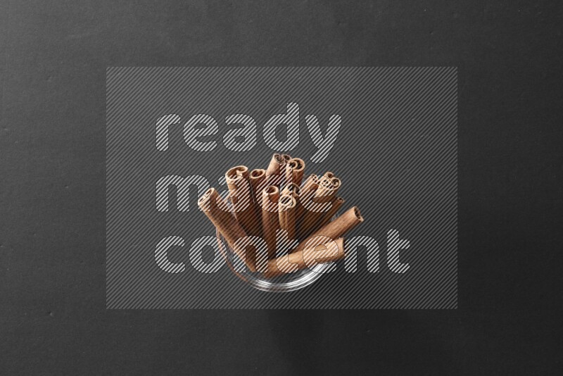 أعواد القرفة في وعاء زجاجي علي خلفية سوداء