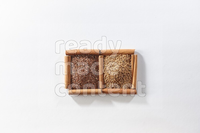 2 squares of cinnamon sticks full of mustard seeds and flaxseeds on white flooring