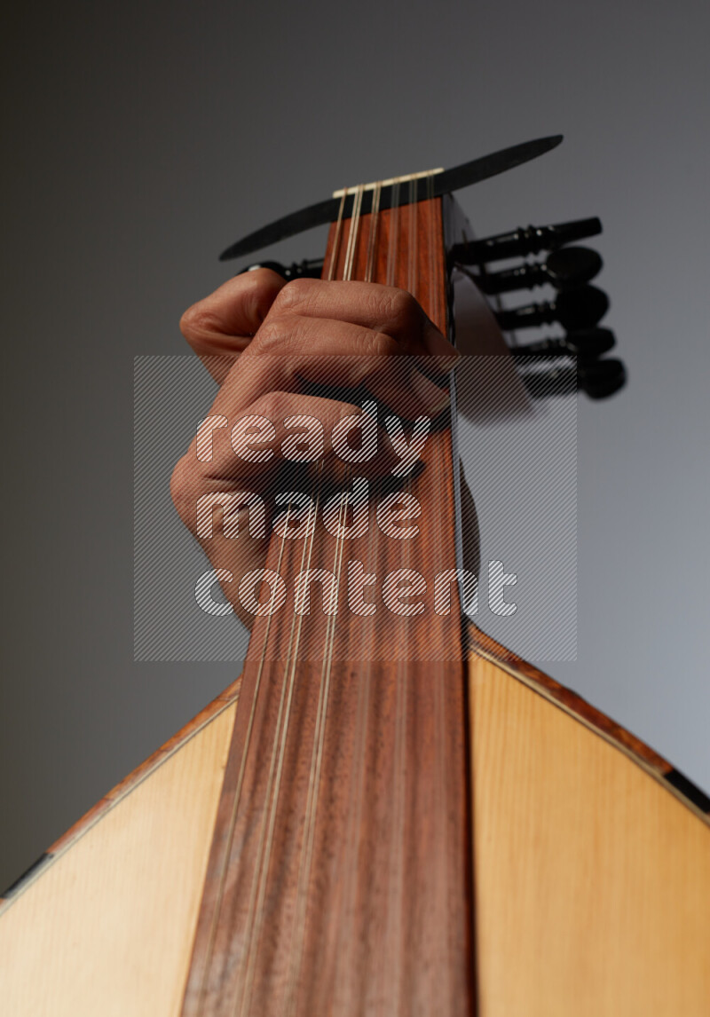 يد رجل تعزف على عود خشبي بني