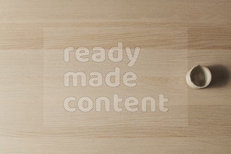 A pottery cup on light wooden background