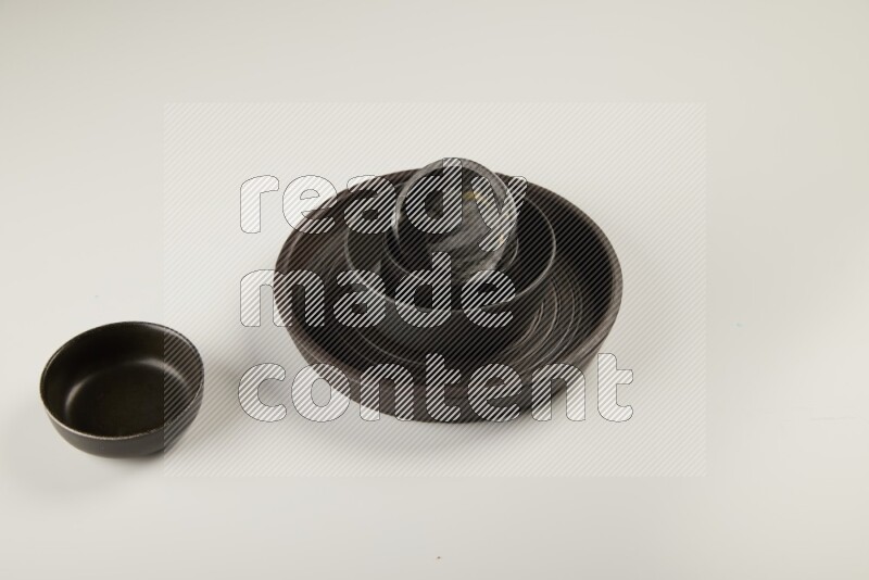 black pottery plate and black bowls on white background