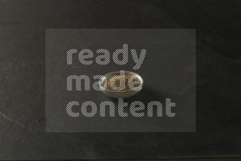 multi color round sauce bowl filled with herbs on grey textured countertop