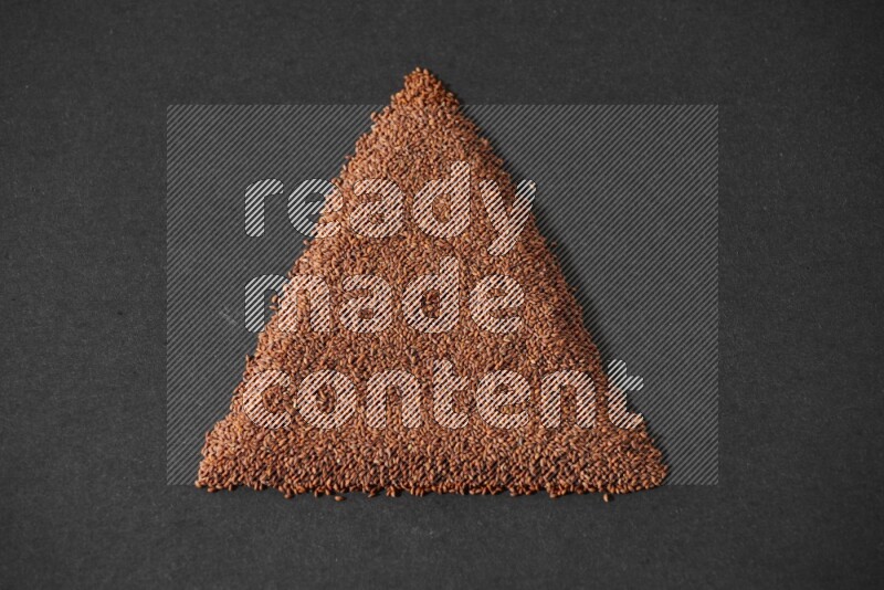 Garden cress seeds in a triangle shape on a black flooring