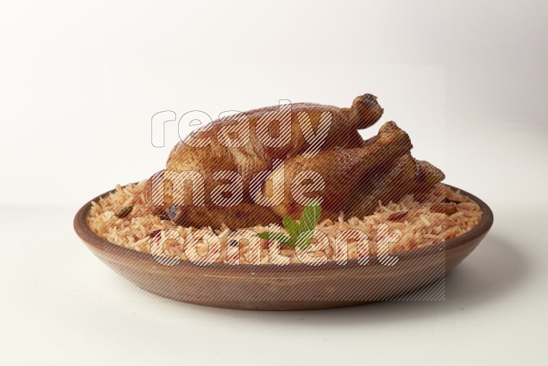 red basmati Rice with whole roasted chicken on a pottery plate direct on white background