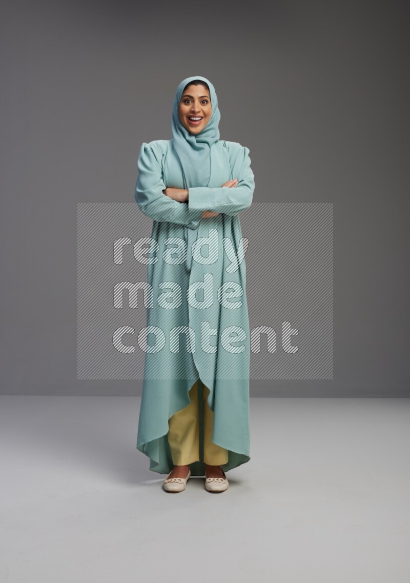 Saudi Woman wearing Abaya standing with crossed arms on Gray background