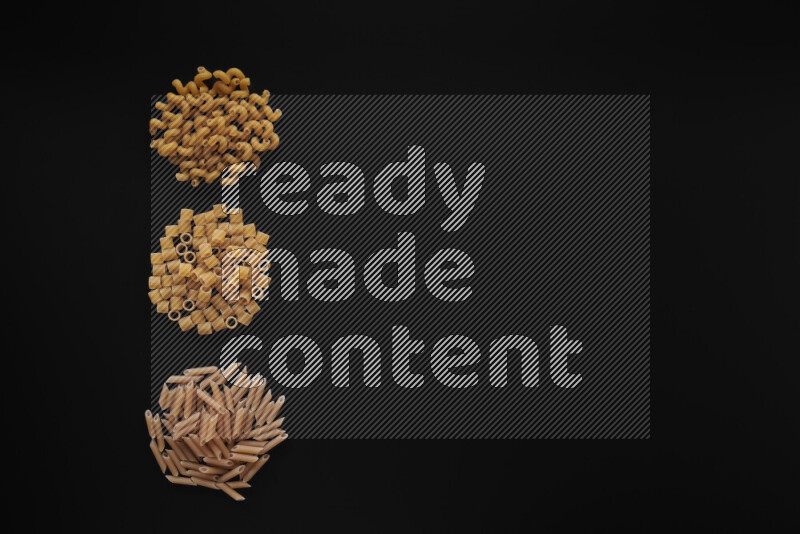 Different pasta types in 3 bunches on black background