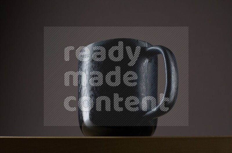 Low angle shot of a black cup on grey background