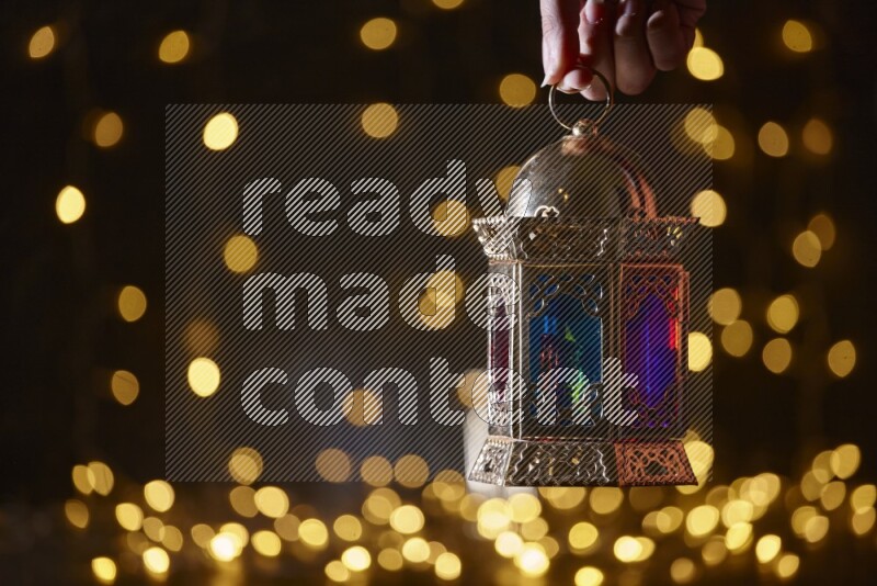 A traditional ramadan lantern surrounded by glowing fairy lights in a dark setup