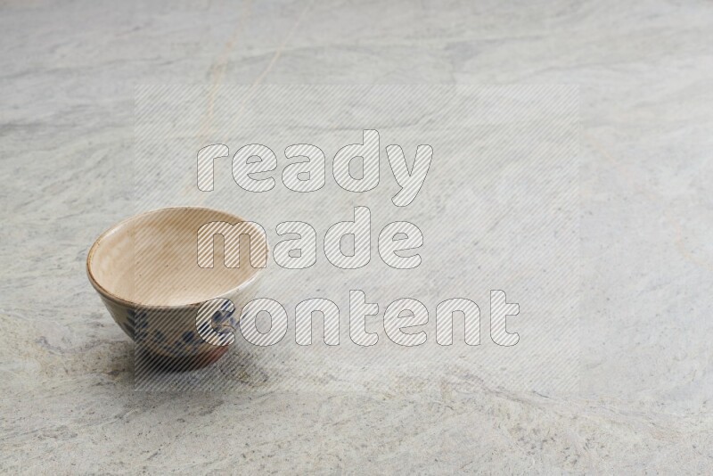 A multicolored pottery bowl on grey marble background