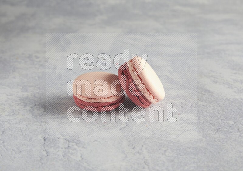 45º Shot of two Pink Litchi Raspberry macarons  on white  marble background