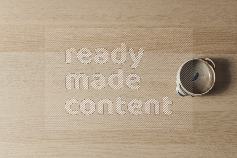 وعاء فخاري متعدد الألوان على خلفية خشبية فاتحة