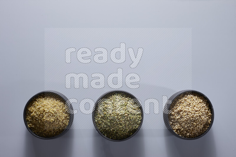 Legumes in pottery bowls on light grey background