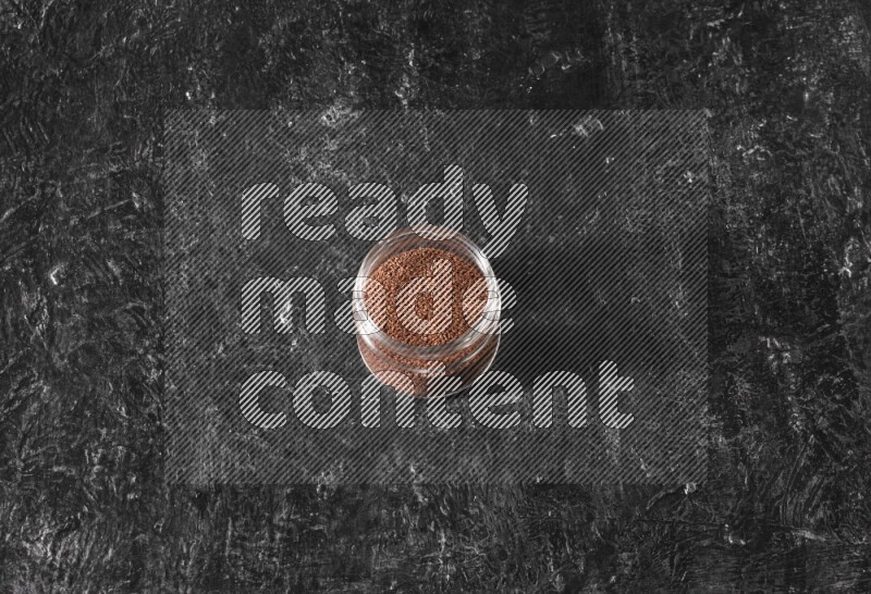 وعاء زجاجي ممتلئ ببذور حب الرشاد على أرضية سوداء