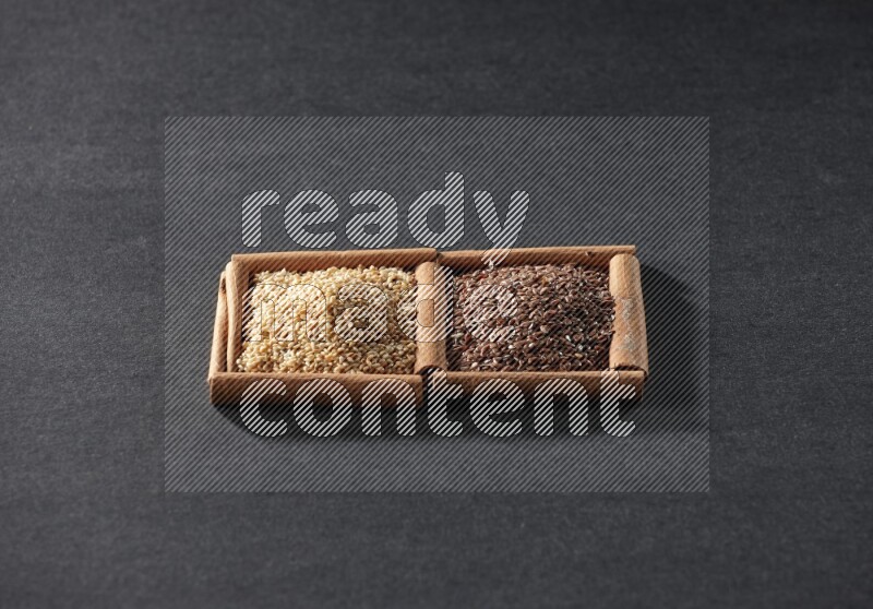 2 squares of cinnamon sticks full of flaxseeds and sesame on black flooring