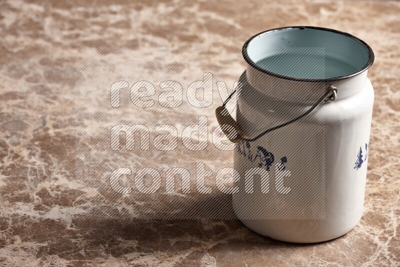 A vintage milk can on beige marble background