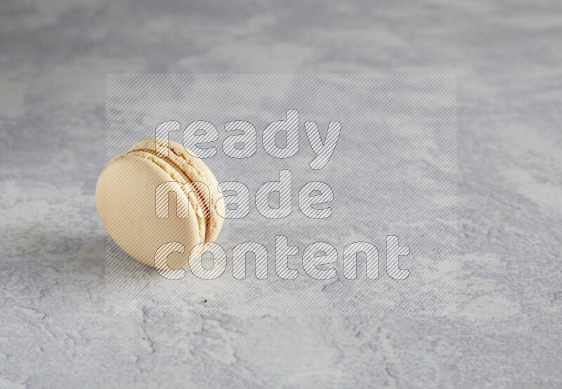45º Shot of white marbleCaramel fleur de sel macaron on white  marble background