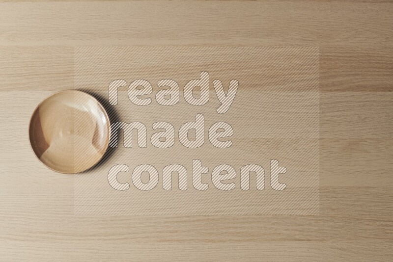 صحن فخاري متعدد الألوان على خلفية خشبية فاتحة